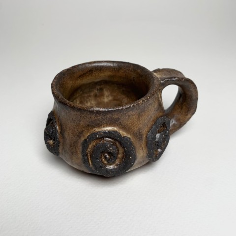 Taza pasta negra esmalte café amarillento. Labrado con pasta expuesta